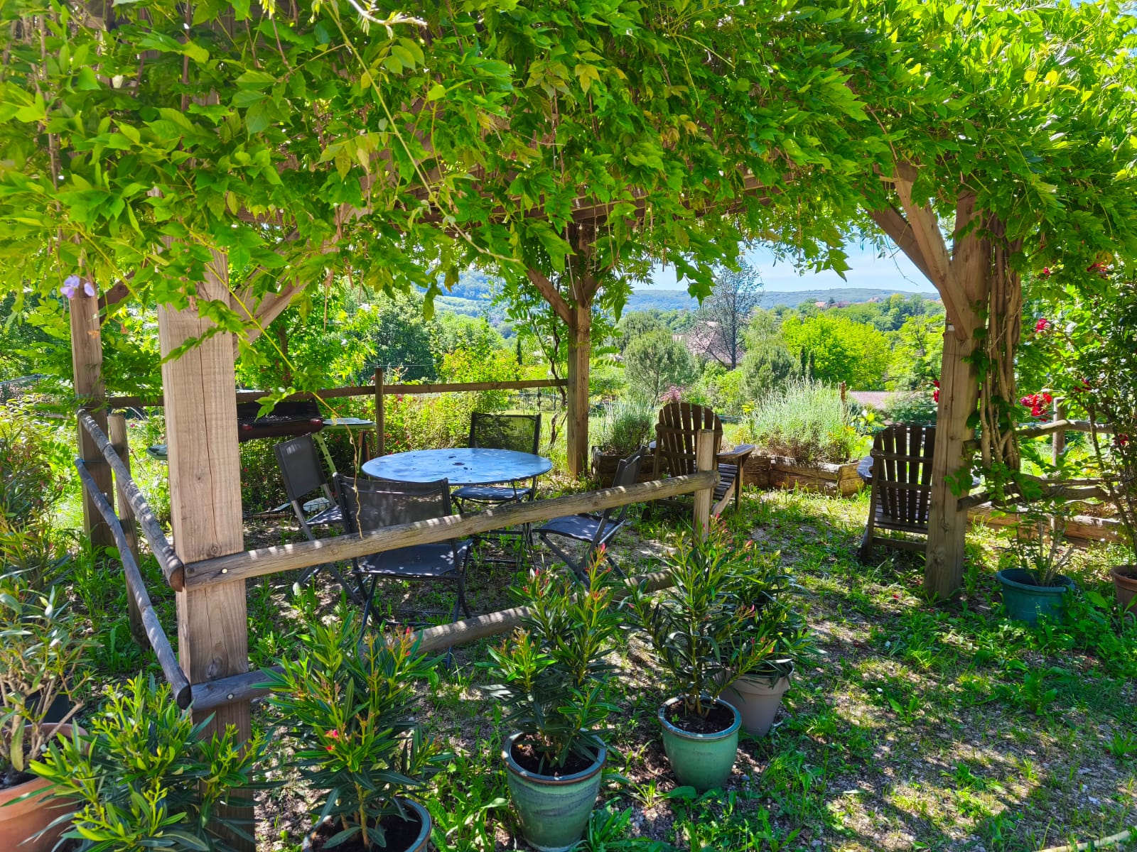 Terrasse ombragée sous la tonnelle, avec vue sur la vallée